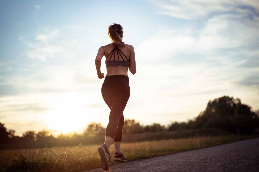 young woman running in sunset