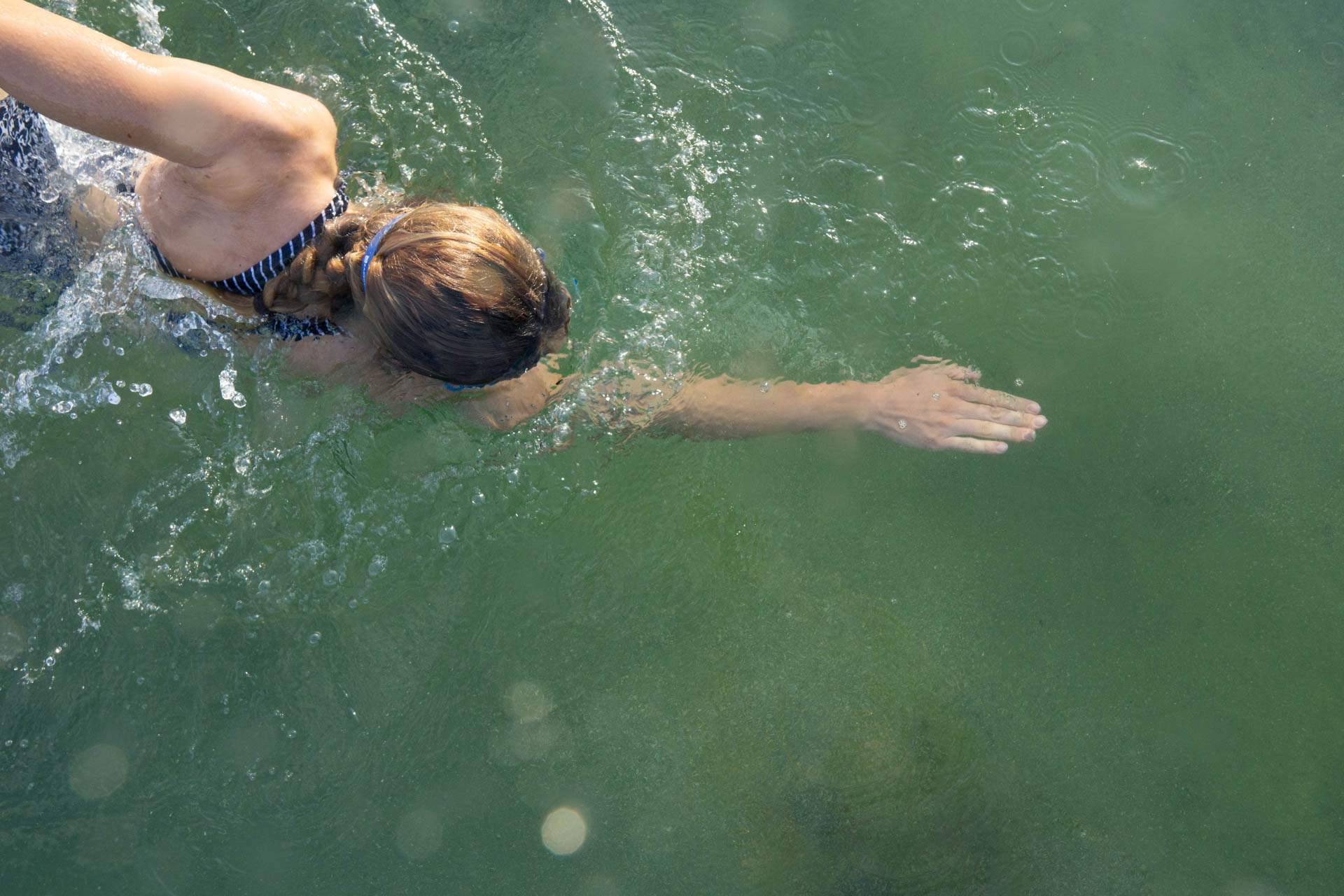 ine Triathletin beim Schwimmen im Kuhsee in Augsburg - sie demonstriert ihre innere Stärke und ihre mentale Entschlossenheit.