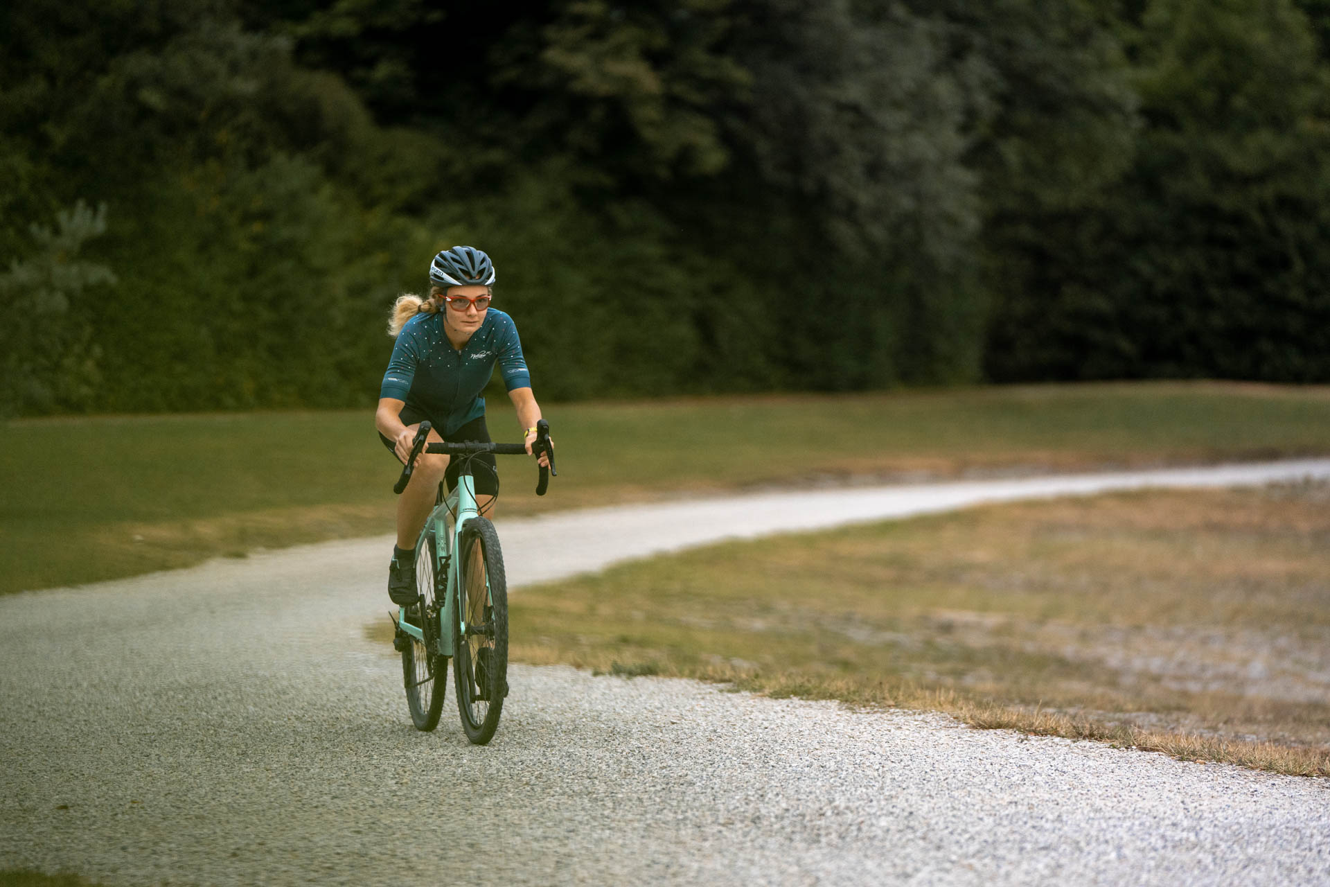 Eine Triathletin beim Fahrradfahren am Kuhsee in Augsburg - sie meistert die Herausforderungen des Triathlons mit Leichtigkeit.