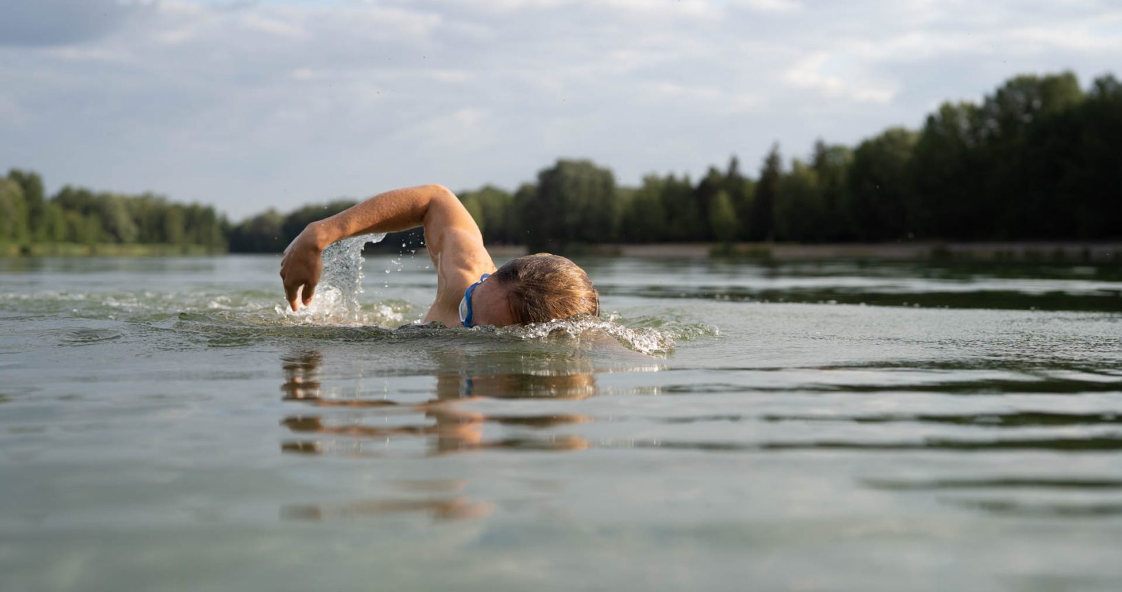 Eine Triathletin beim Schwimmen im Kuhsee in Augsburg - sie demonstriert ihre innere Stärke und ihre mentale Entschlossenheit.