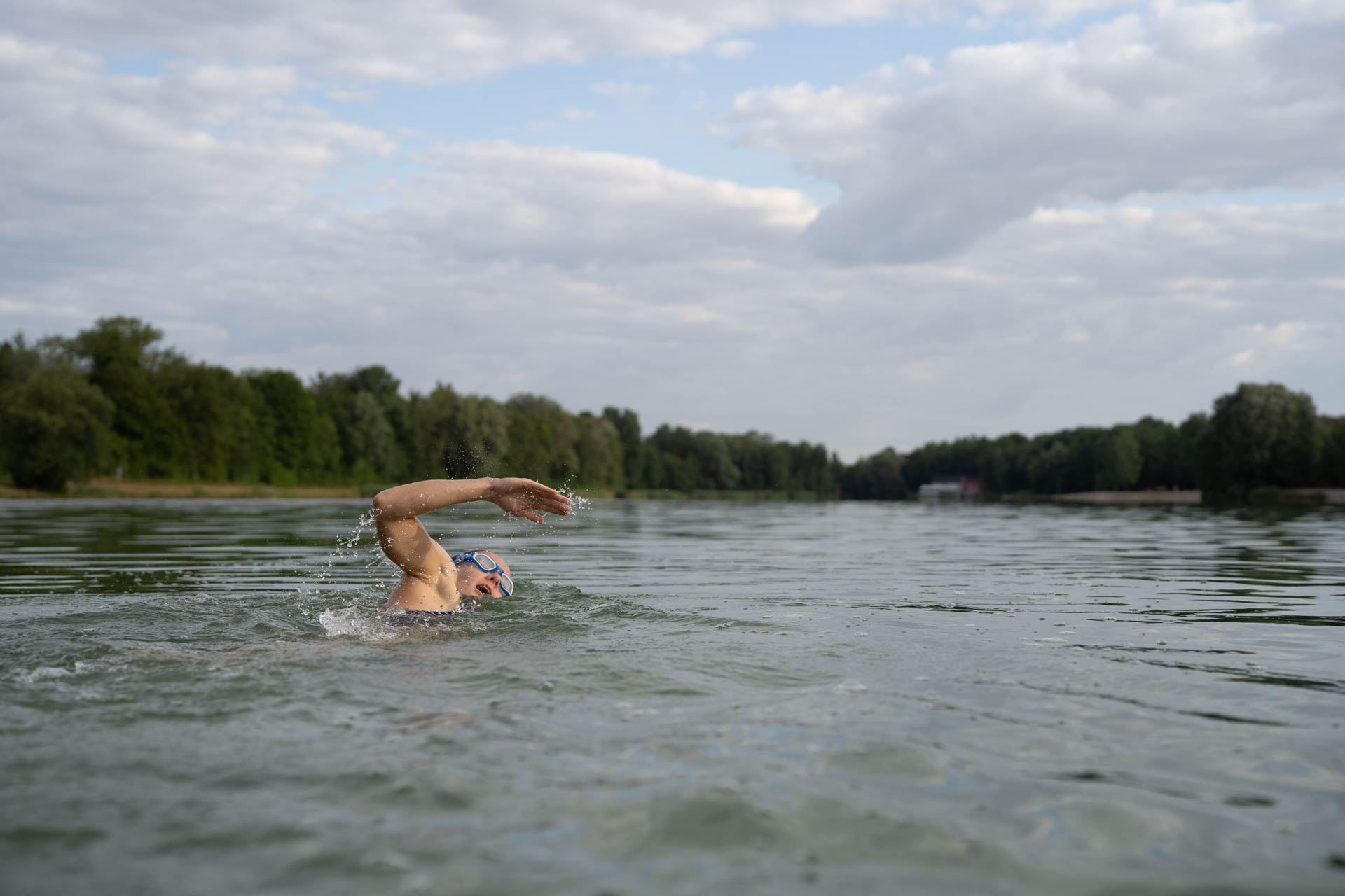Eine Triathletin beim Schwimmen im Kuhsee in Augsburg - sie beweist, dass mit harter Arbeit und Ausdauer alles möglich ist.
